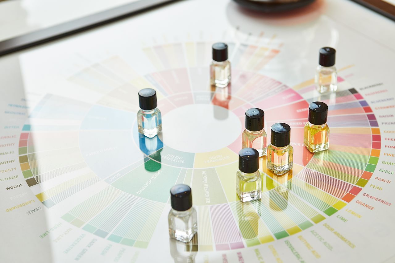 services-01 A collection of small colorful vials on a fragrance wheel, illustrating aroma categories.