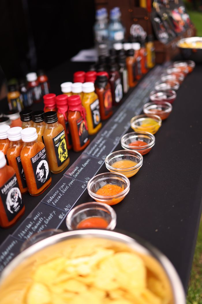 services-01 Variety of flavorful hot sauces and spices on display at an outdoor market stall.