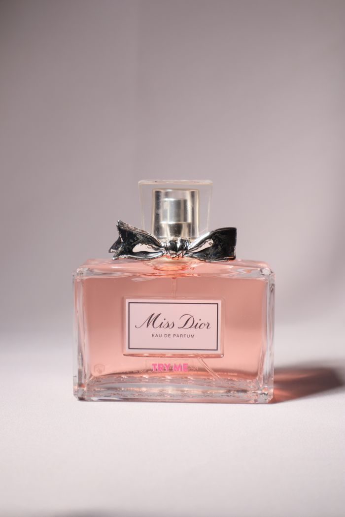vision A sophisticated Miss Dior perfume bottle with a bow, captured in soft lighting.